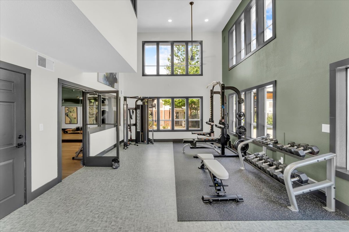 a gym room with a large window and exercise equipment at The Residences at Bear Creek
