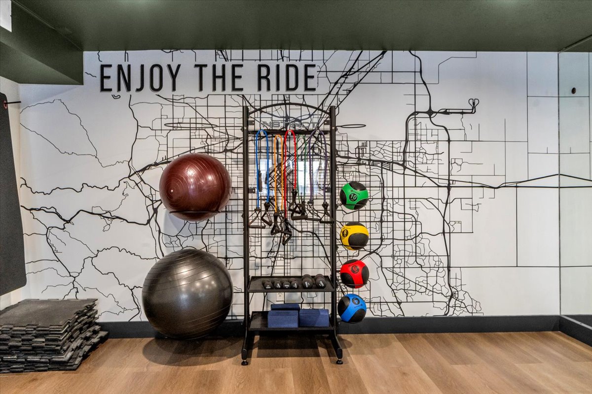 a gym room with exercise balls and a wall with a sign that says enjoy the ride at The Residences at Bear Creek