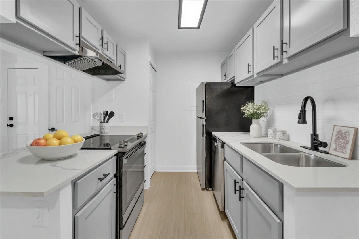 a kitchen with stainless steel appliances and white cabinets at The Residences at Bear Creek